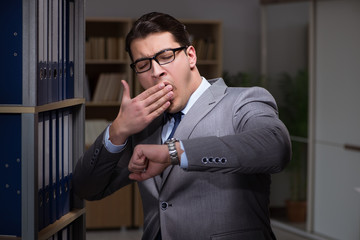 Businessman almost falling asleep working late hours in the offi