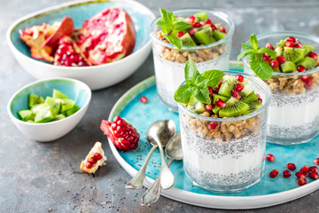 Layered chia pudding parfait with kiwi fruit, pomegranate, granola and yogurt, healthy breakfast