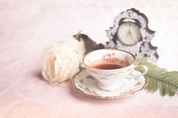 Old antique cup of tea on pink table cloth