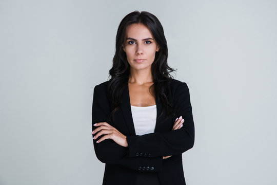 Confidant and beautiful. Beautiful young businesswoman looking at camera while standing against white background