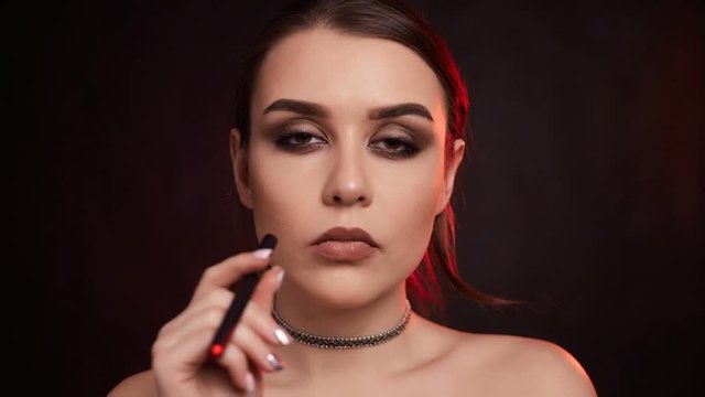 Portrait of glamour seductive gorgeous brunette woman smoking electronic cigarette in studio