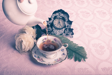 Old antique cup of tea on pink table cloth