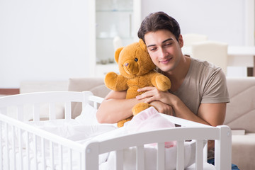 Young father enjoying time with newborn baby at home