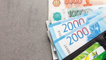new Russian banknotes in denominations of 1000, 2000 and 5000 rubles and credit cards in a black...