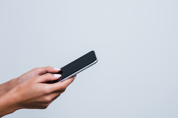 Technology in hands. Close up part of young woman with beautiful hands holding smartphone against white background