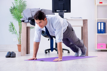 Businessman doing sports in office during break