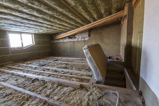 House attic under construction. Mansard walls and ceiling insulation with rock wool. Fiberglass insulation material in wooden frame for cold barrier