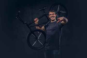 A handsome man with BMX in a studio.