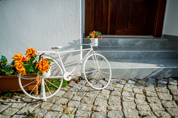Fototapeta na wymiar White bicycle near old house wall