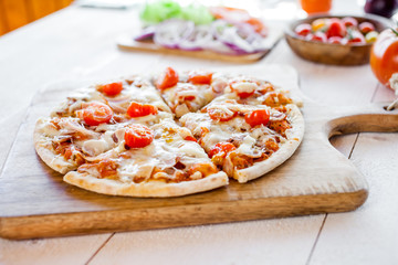 hot fresh homemade traditional italian pizza on wooden table. wallpaper for pizzeria and cooking food concept. soft focus