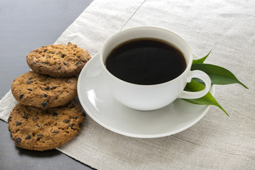 A white coffee mug on the table. cookies with chocolate. Close-up