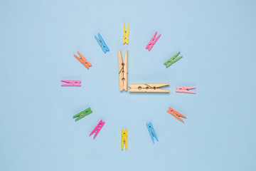 Top view of small colorful clothes pins forming clock