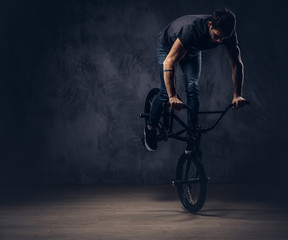 A handsome man with BMX in a studio.