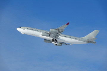Fototapeta na wymiar avion de ligne gris et blanc ciel bleu