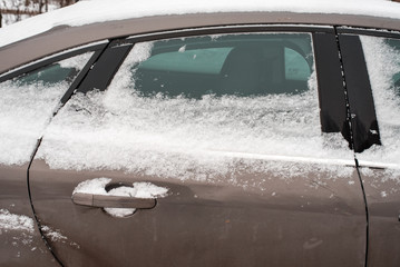 The car in the snow, covered with white snowdrift.