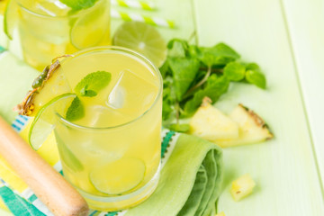Pineapple and lime drink on rustic background