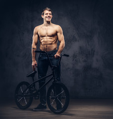 Fototapeta na wymiar A handsome man with BMX in a studio.