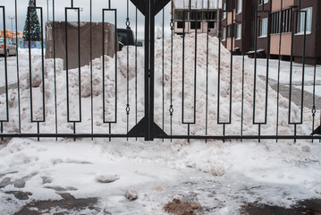 Metal black fence. In winter snow drifts in the parking area. Close to home.