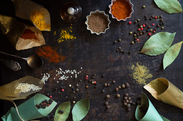 Different food spices scattered on a dark