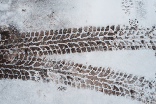 Close-up of car tracks in the snow. Winter in city. The first snow traces the truck.