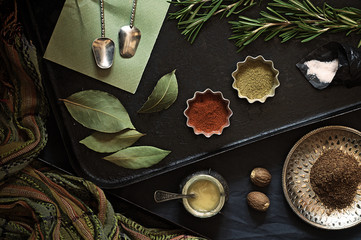 Various dry food spices and seasonings on a black pan