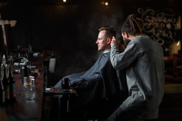 Barber cutting hair of customer. Small business