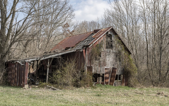 A decaying wooden barn in a rural area. 
