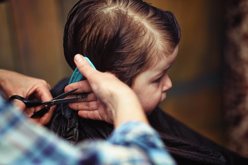 Obraz premium A little boy is trimmed in the hairdresser's 