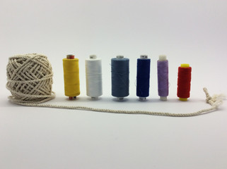 Thread rolls in line on white backround with rope ball