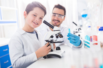 Cheerful vigorous boy discovering microorganisms