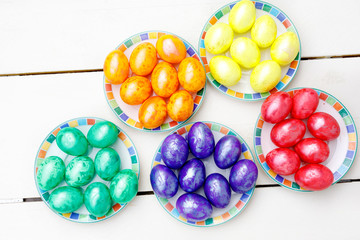 Easter eggs on wooden background. Colorful eggs in different colors - red, yellow, orange, purple and green.