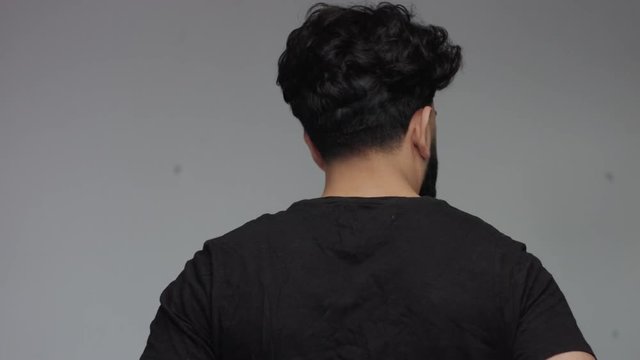 man from the back then turning to look at camera in studio