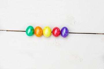 Easter eggs on wooden background. Colorful eggs in different colors - red, yellow, orange, purple and green.