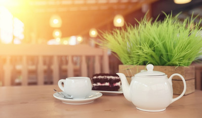 Kettle with a drink and dessert in a street cafe. Tea in the ket