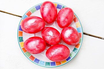 Easter eggs on wooden background. Colorful eggs in different colors - red, yellow, orange, purple and green.