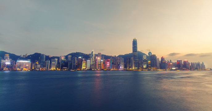 Scenic skyline of Hong Kong island with skyscrapers. Victoria harbor at sunset. Colourful travel background.