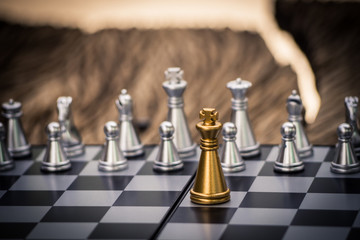Gold and silver King and Knight of chess battle on board . Gold king are leader to fight with teamwork to victory.  Leader and teamwork concept for success.