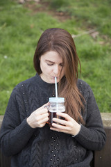 Young beautiful woman drinking coffee while outdoors 