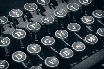 A close up shot of a vintage typewriter. This image can be used to represent the concept of writing. 