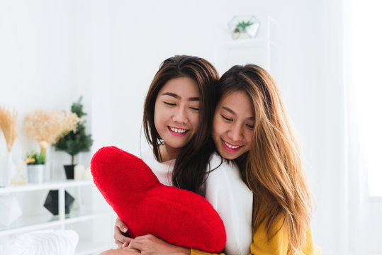 Beautiful young asian women LGBT lesbian happy couple sitting on bed hugging and smiling together in bedroom at home. LGBT lesbian couple together indoors concept. Spending nice time at home.