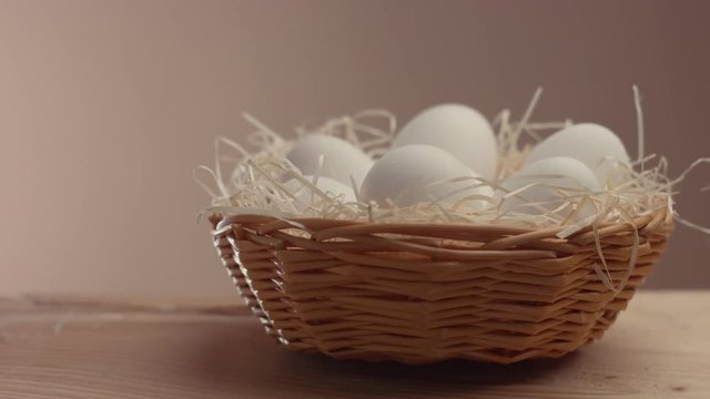 pan movemet closeup eggs in a basket on a beige background
