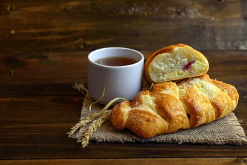 homemade cakes - pastries with cream cheese and strawberry jam and a white Cup of tea on dark...