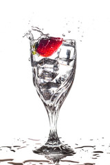 Strawberry splashing into glass of water
