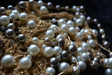 gold threads with pearls on black silk, beautiful luxury background