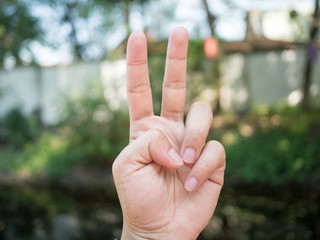 background.Men's hand.Hold two fingers..Be a symbol to fight or not give up.