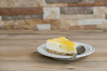 Cheese cake in the small plate on the wooden table.