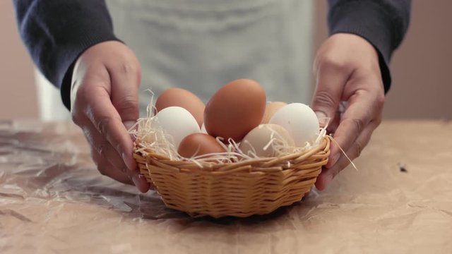 man put a basket with eggs on the table from the blur to focus