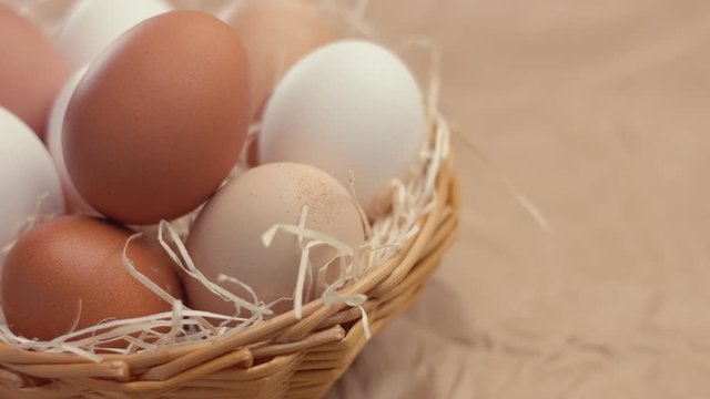 woman's hand put a n egg to another ones in basket. closeup