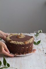 Walnut cake on a table with hands