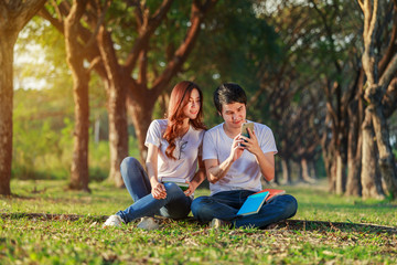 couple using mobile phone in park